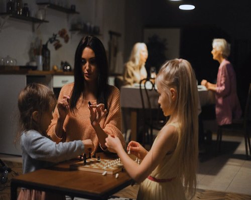 Family playing a board game together in a warm living room