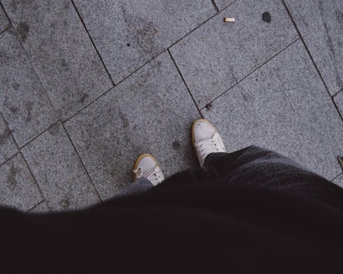 Comfortable sneakers walking on a paved city sidewalk